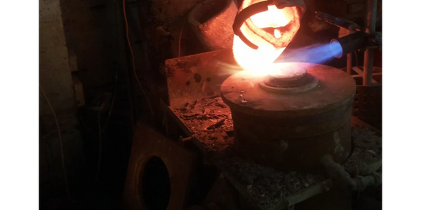 Molten silver being poured into flask in vacuum machine