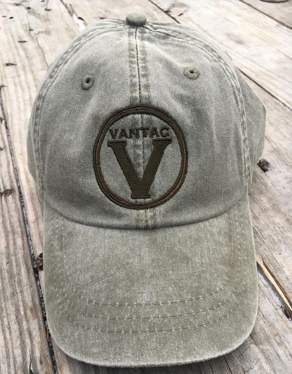 Olive green VANTAC baseball cap on wooden surface.