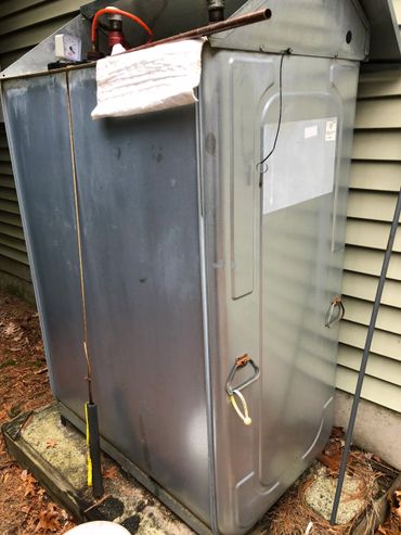 Large industrial metal equipment unit outdoors beside a building.