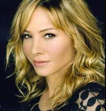 Portrait of a woman with blonde hair and a black lace top.