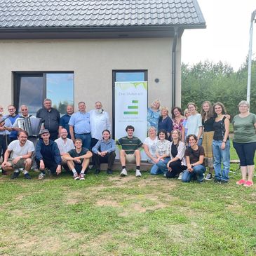 Gruppenfoto von Menschen vor einem Gebäude bei Tageslicht.