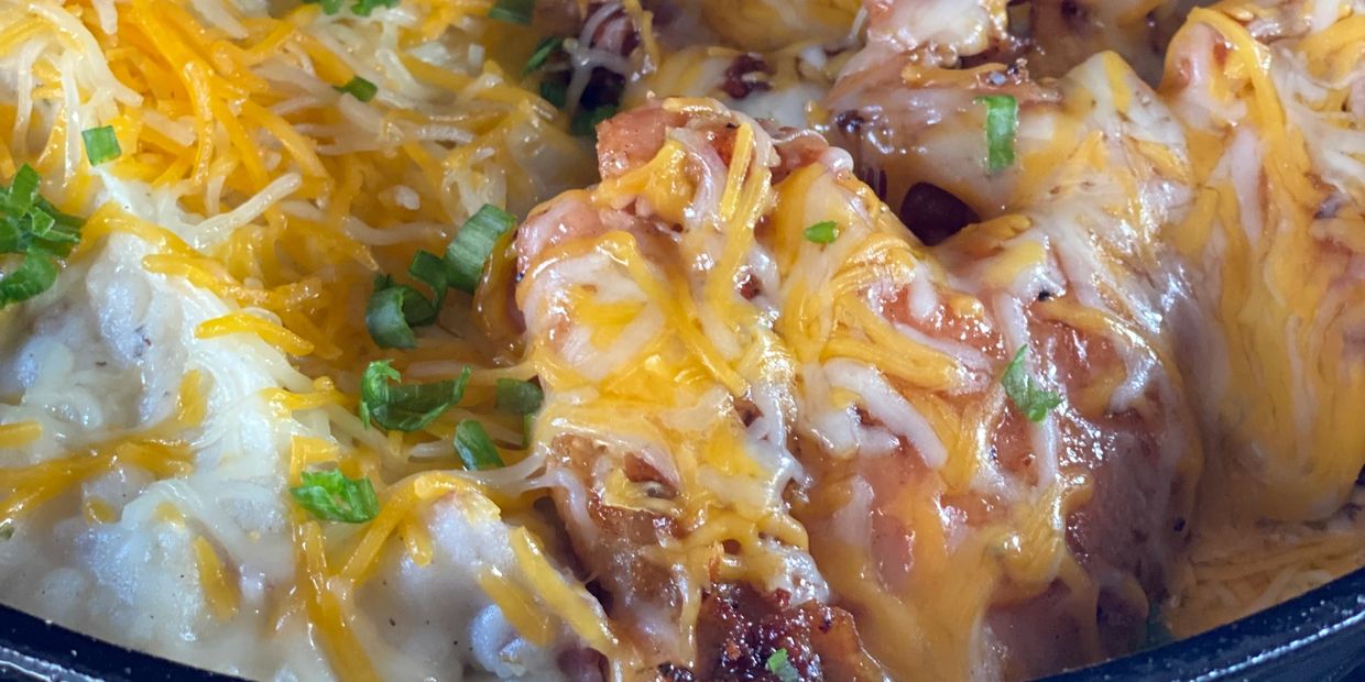 Sizzlin Chicken & Cheese in a cast iron pan.