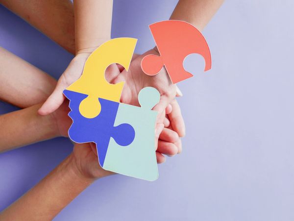 Hands holding jigsaw puzzle head shape