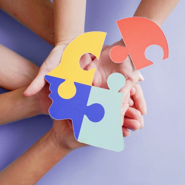 Hands holding jigsaw puzzle head shape