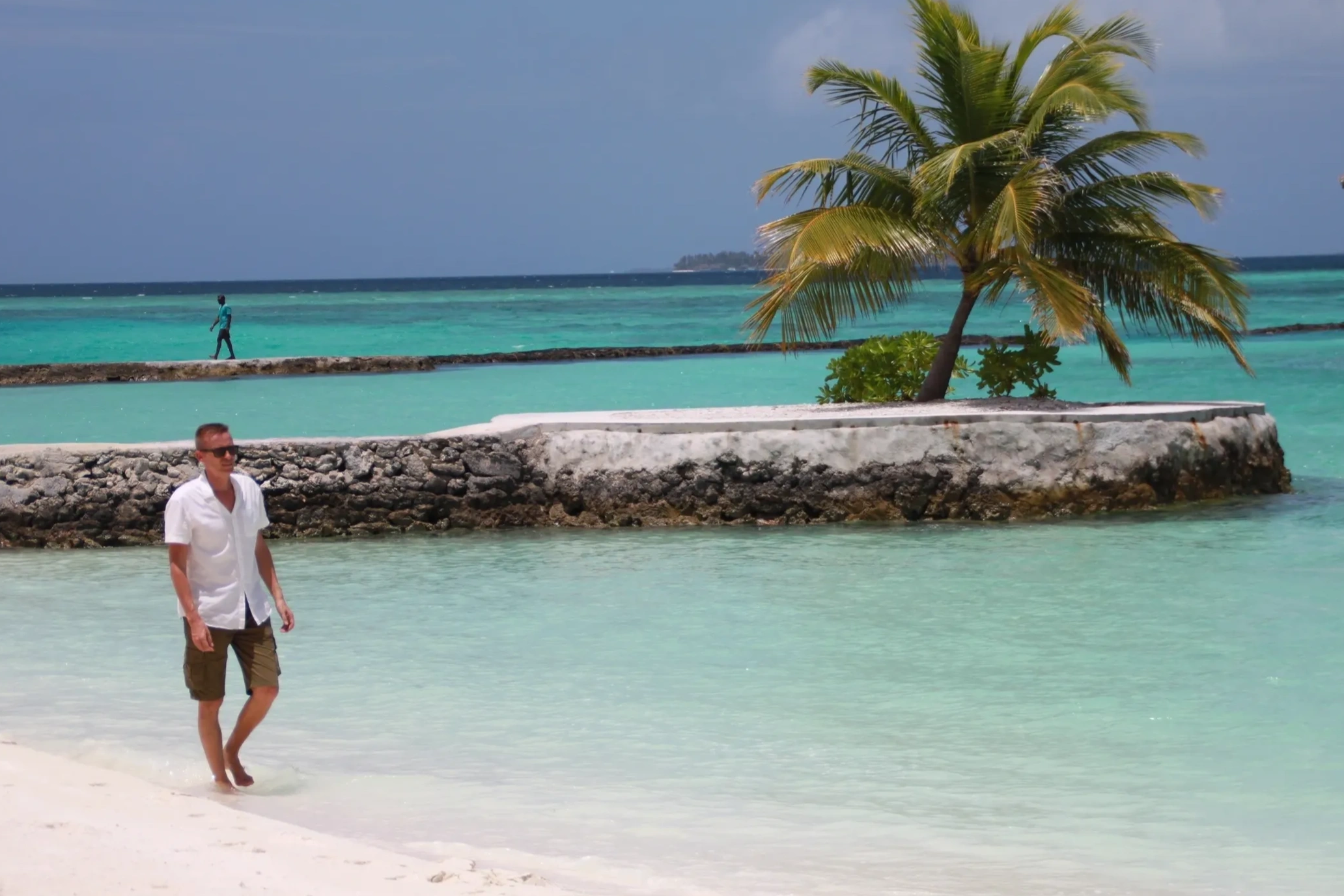 Author Jarmo Syväri is walking on a white sandy beach in the Maldives.