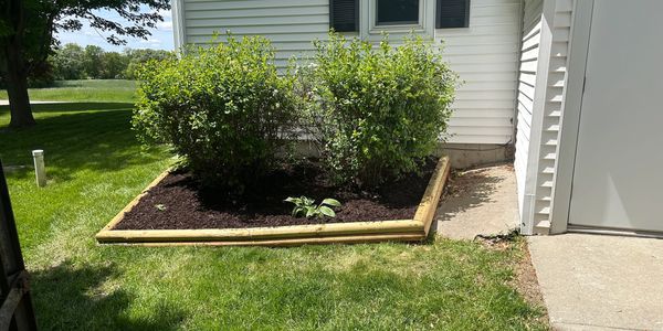 Updated and expanded landscape timber job with brown mulch