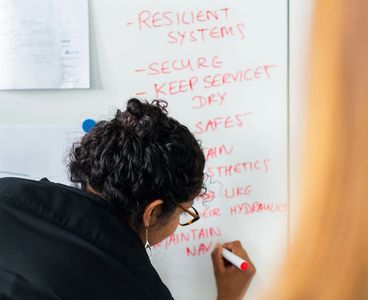A woman writing a list on a whiteboard
