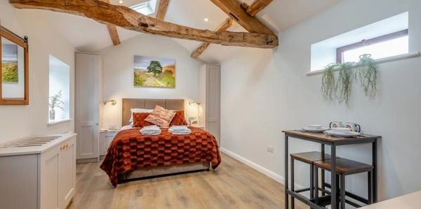 Cozy rustic bedroom with wooden beams and warm decor.