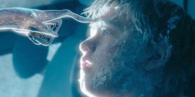 A frozen boy touched by an icy alien hand in a sci-fi scene.