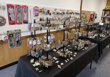 Display of jewelry and vintage thermometers in a shop.