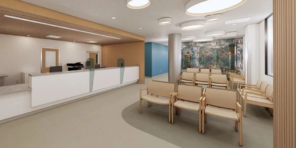 Modern waiting room with beige chairs and a reception desk.