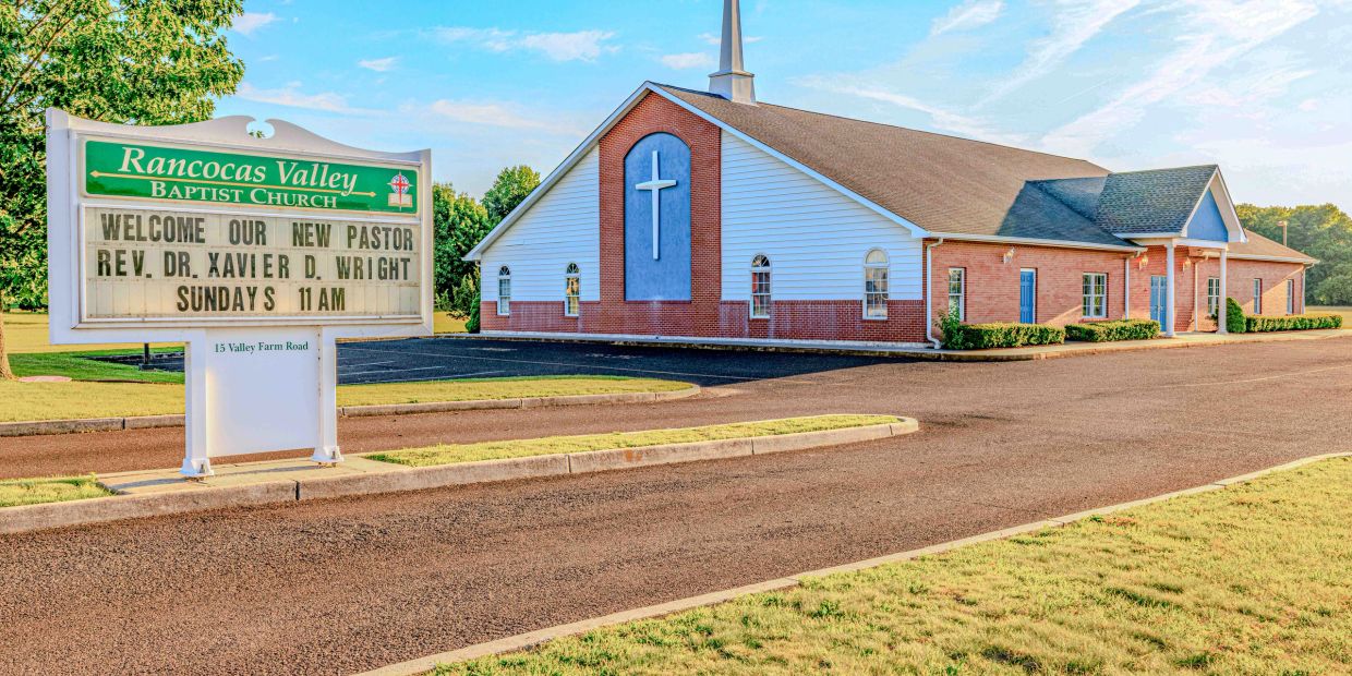 Church building and sign welcoming a new pastor.