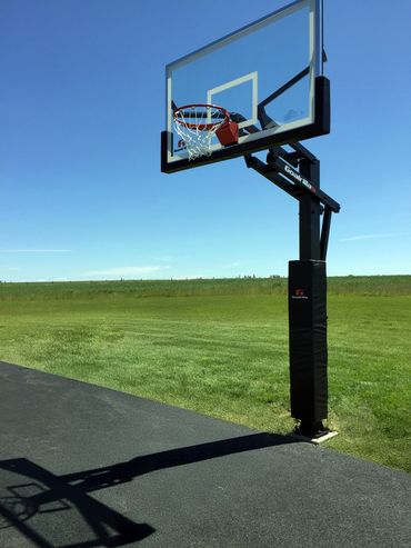 Professional-grade basketball hoop installation with tempered glass backboard and adjustable height.