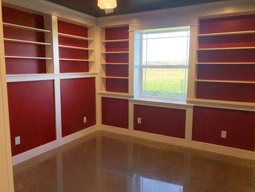 Finished basement bedroom with built-in shelves and polished concrete flooring.