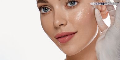 Mujer con gotas de producto marcadas en su mejilla y una mano enguantada sostiene una jeringa