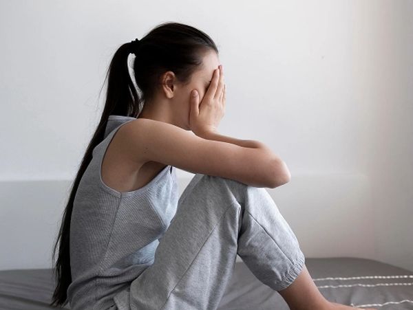 full-shot-depressed-woman-bed