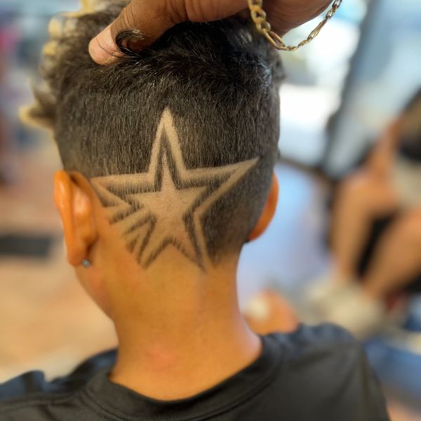 Intricate star design shaved into the back of a person's head.