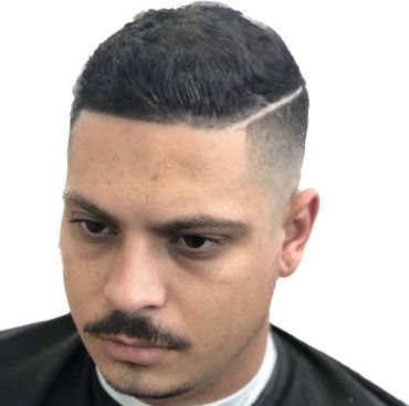Man with a fresh haircut featuring a hard part and fade.