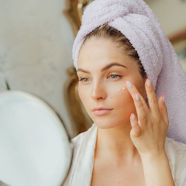 Woman With Head Towel Applying Face Cream