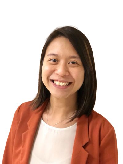 Smiling woman in a rust-colored blazer and white top.