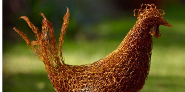 Wire sculpture of a chicken with intricate loops and textures.