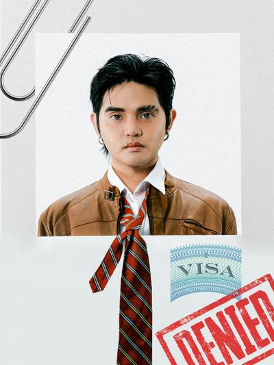 Portrait of a young man with a denied visa stamp.