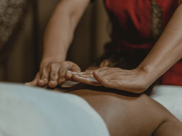 Hands giving a relaxing back massage to a person.