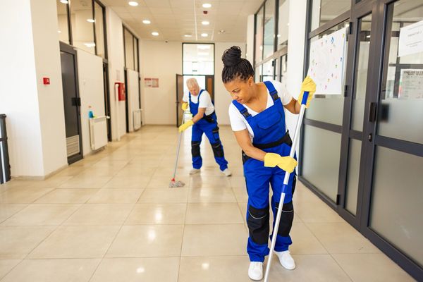 Janitors cleaning the floor in High school building