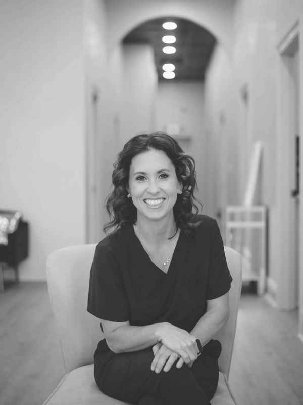 Licensed esthetician at A Hidden Gem Beauty Bar in Mandeville, LA, sitting in a treatment hallway
