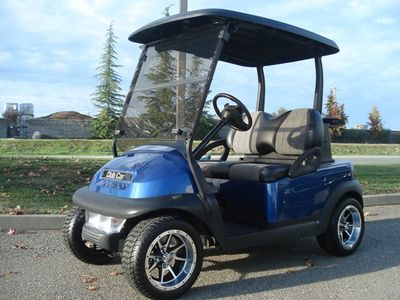 Blue Club Car golf cart parked outdoors on a sunny day.