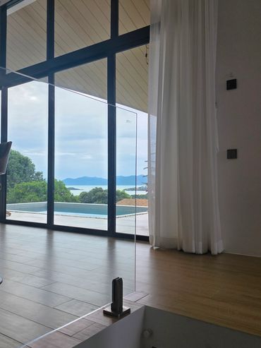 Modern interior with glass doors overlooking a pool and scenic mountain view.