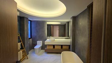 Modern bathroom with sleek fixtures, illuminated mirror, and ambient ceiling light.