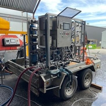 Industrial equipment mounted on a trailer under a shelter.