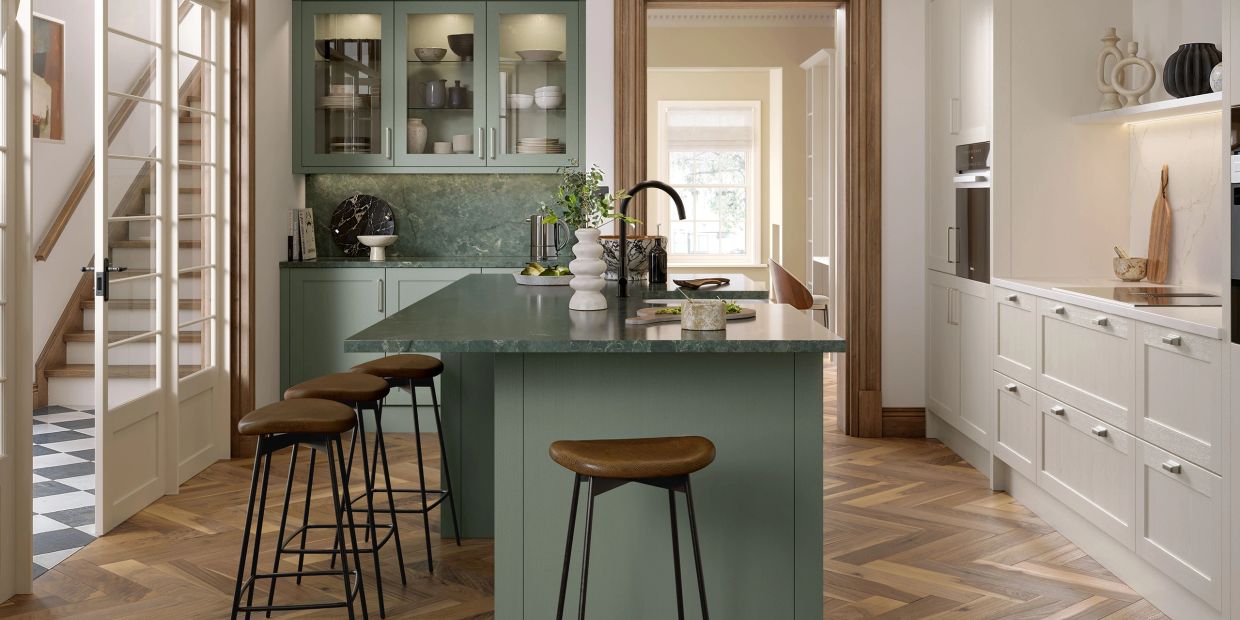 Modern kitchen with green cabinetry and wooden stools.