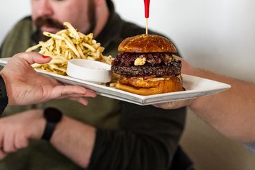 A manhole burger with spicy food on the plate