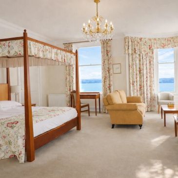 Elegant bedroom with floral decor and ocean view.