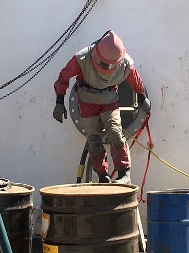 Brad coming out of access hole of storage tank in Modest, CA.