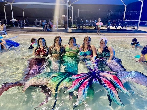 Colorful mermaids swimming under the stars.