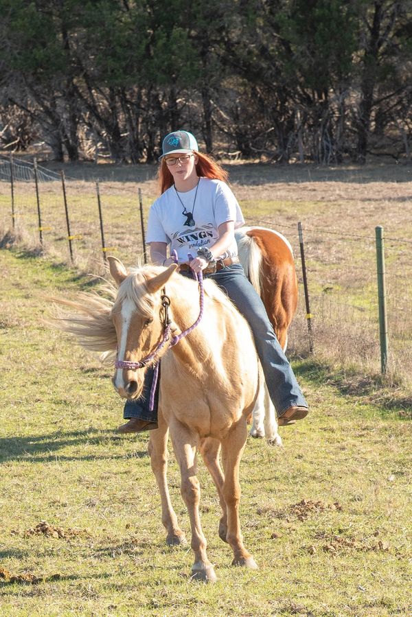 Teen girl riding horse during equine-assisted learning session