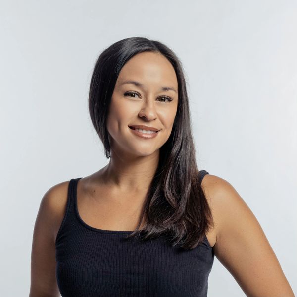Smiling woman with long dark hair in a black tank top.