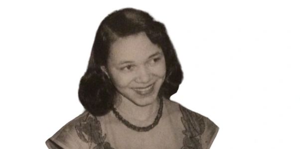 Black and white photo of a smiling woman with dark hair.