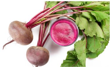 Fresh beetroots with leaves and a glass of vibrant beetroot juice.