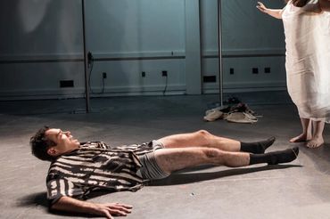 Two people engaged in a dramatic performance with flowing fabric and expressive poses.