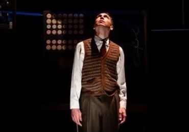Man in spotlight surrounded by floating screens showing faces and text.