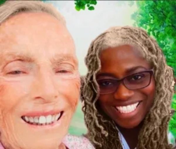 kind Black caregiver takes photo with senior in ethereal garden plane.