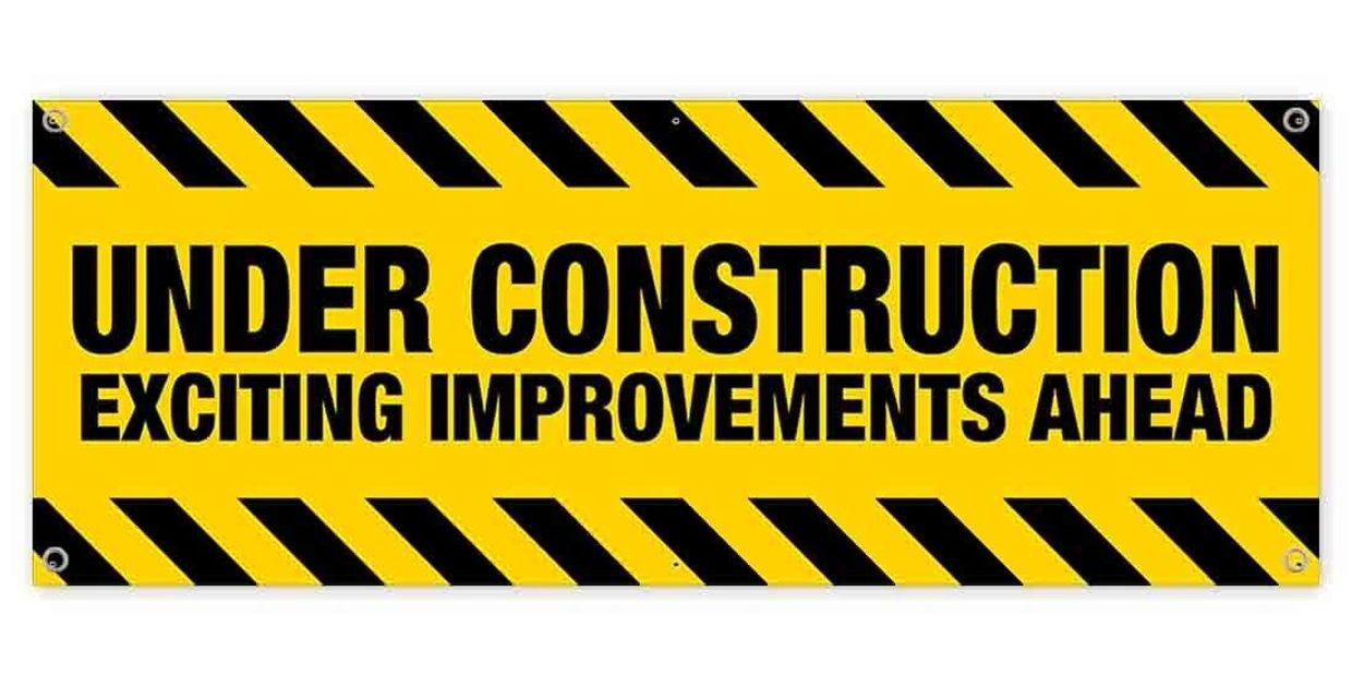 Yellow and black sign reading 'UNDER CONSTRUCTION EXCITING IMPROVEMENTS AHEAD'.