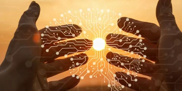 Hands holding a glowing circuit chip against a sunset background.