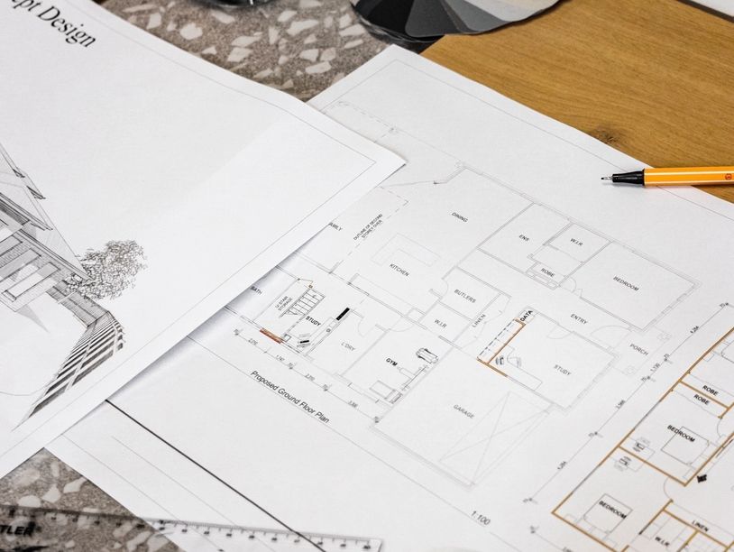 Architectural floor plans and design sketches on a table.