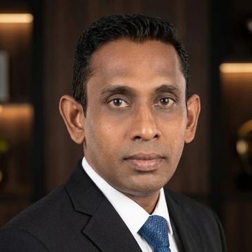Professional headshot of a man in a suit and tie.