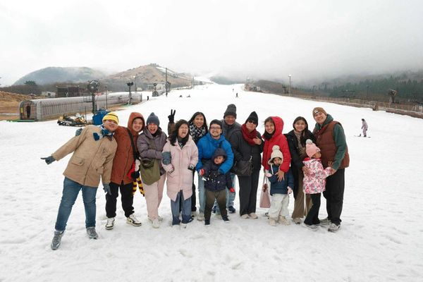 A joyful group of people posing together on a snowy slope.